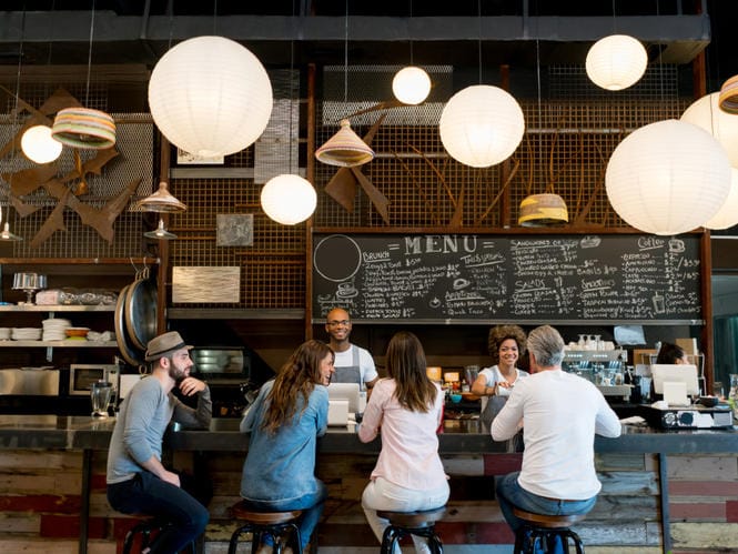 Menschen in einem kleinen Café Beispiel SWOT-Analyse für ein kleines Café: Begrenzte Sitzplatzkapazität dafür Lokale Stammkunden.